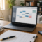 Mesa de home office com notebook, agenda, celular e balança da justiça para artigo sobre horas extras no teletrabalho